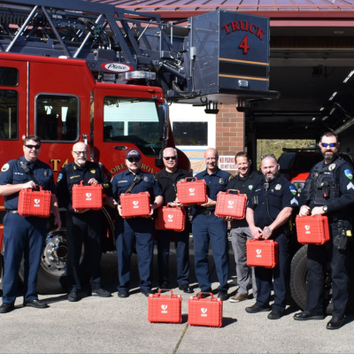 Forest Grove police and firefighters hold ten donated AED devices